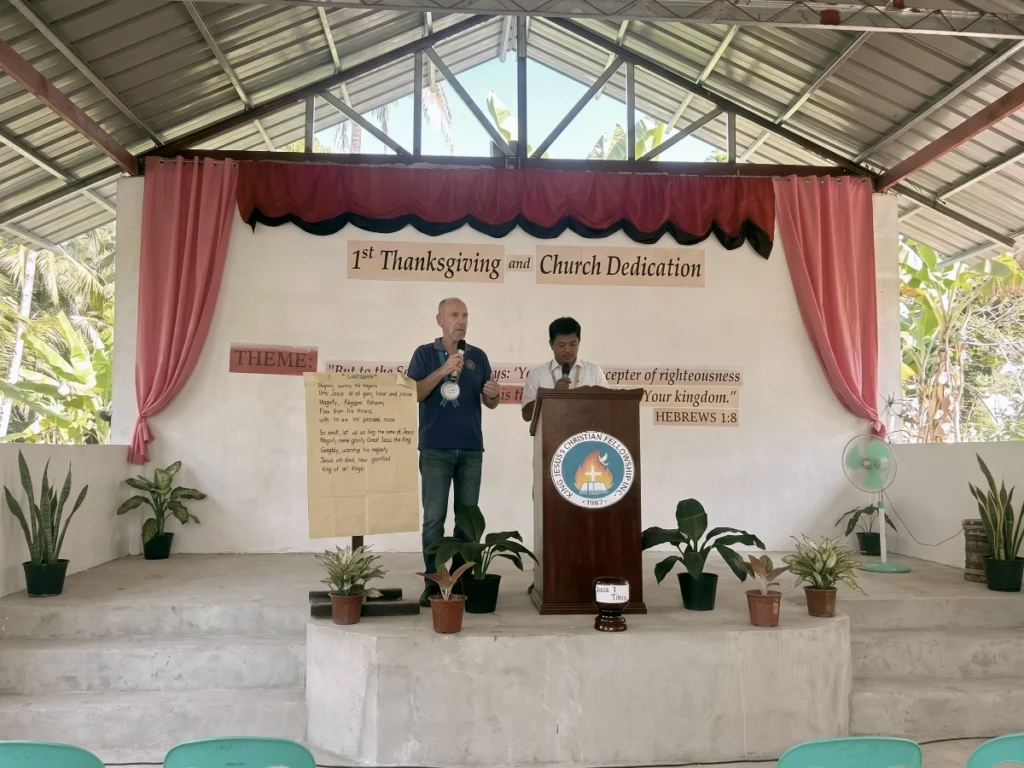 Speakers standing at the podium during the first Thanksgiving and church dedication service inside the newly constructed open-air chapel.